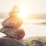 rock cairn with "mind - body - soul" handwritten as superimposed text